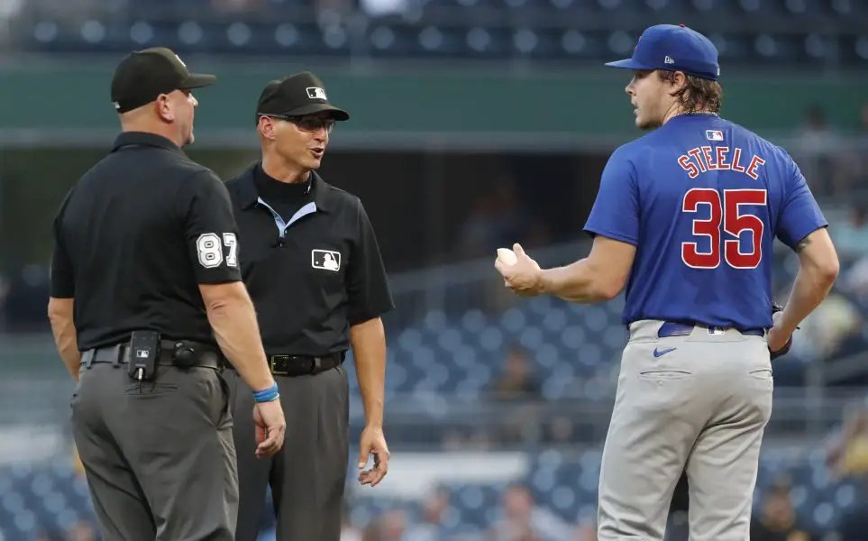 MLB umpires umpire Scott Barry (87) and Vic Carapazza (middle) talk with Chicago Cubs starting pitcher Justin Steele (35) against the Pittsburgh Pirates during the third inning at PNC Park.