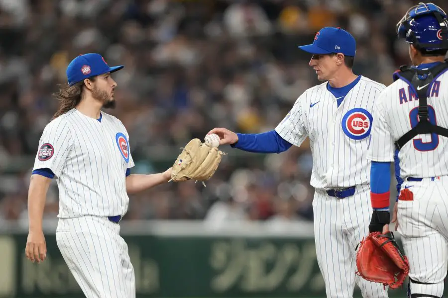 Chicago Cubs manager Craig Counsell (center right) hands the game ball to pitcher Eli Morgan (left) during the fifth inning against the Hanshin Tigers at Tokyo Dome.