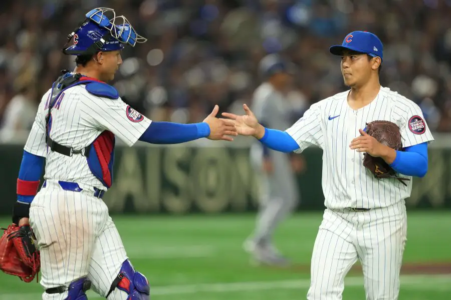 Chicago Cubs starting pitcher Shota Imanaga (18) (right) shakes hands with catcher Miguel Amaya (9) (left) after the top of the second inning concludes against the Los Angeles Dodgers during the Tokyo Series at Tokyo Dome.