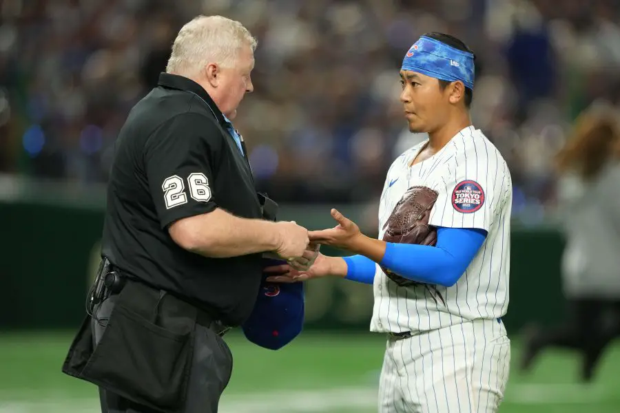 Home plate umpire Bill Miller (26) checks Chicago Cubs catcher starting pitcher Shota Imanaga (18) hands after the top of the second inning concludes against the Los Angeles Dodgers during the Tokyo Series at Tokyo Dome. 